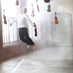 Photography workshop in Montreal. Violinist flying in the air with violins.